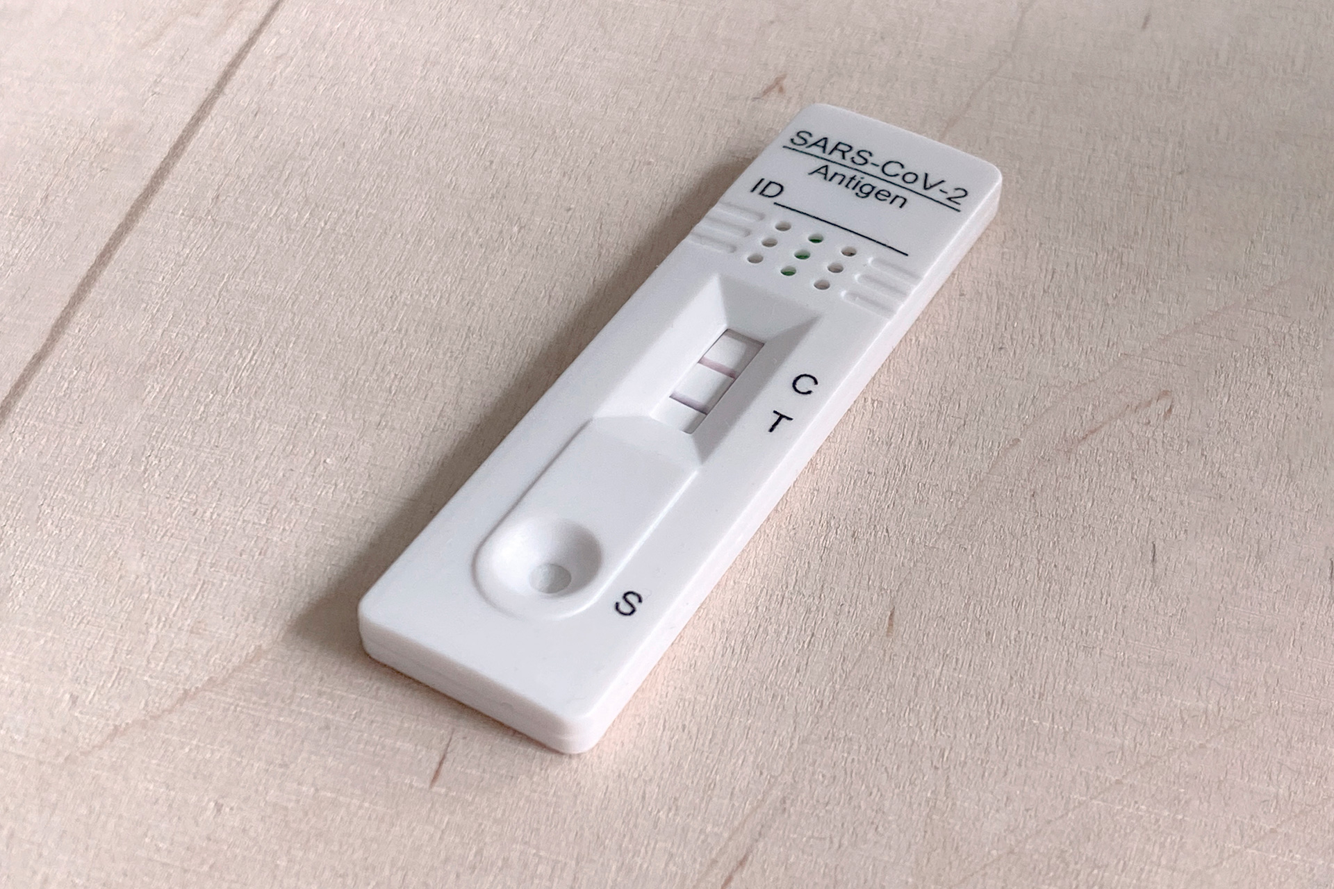 Pöydällä oleva koronakotitesti, jossa kaksi viivaa testituloksena