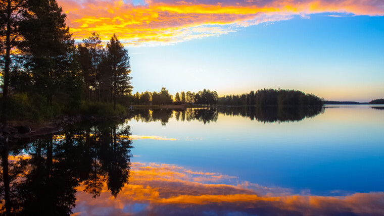 Kuva tyynestä järvimaisemasta auringonlaskun aikaan kesällä