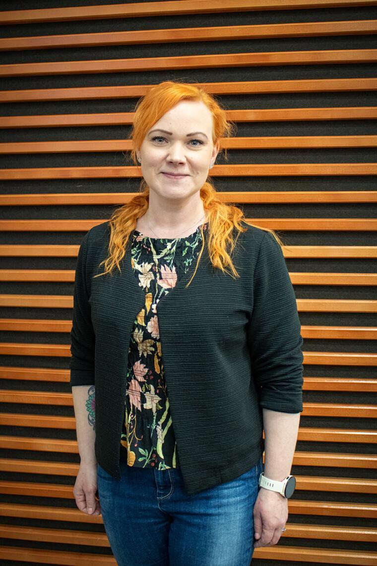 Niina Harju seisoo auditoriossa ja hymyilee.