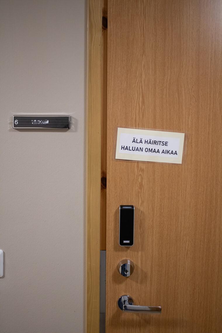 Asukashuoneen ovi, jossa lappu jossa lukee "Älä häiritse, haluan olla rauhassa".